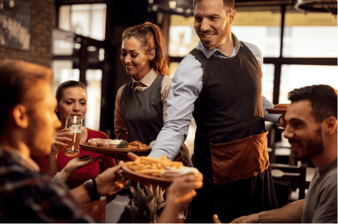 Happy waiters serving food.