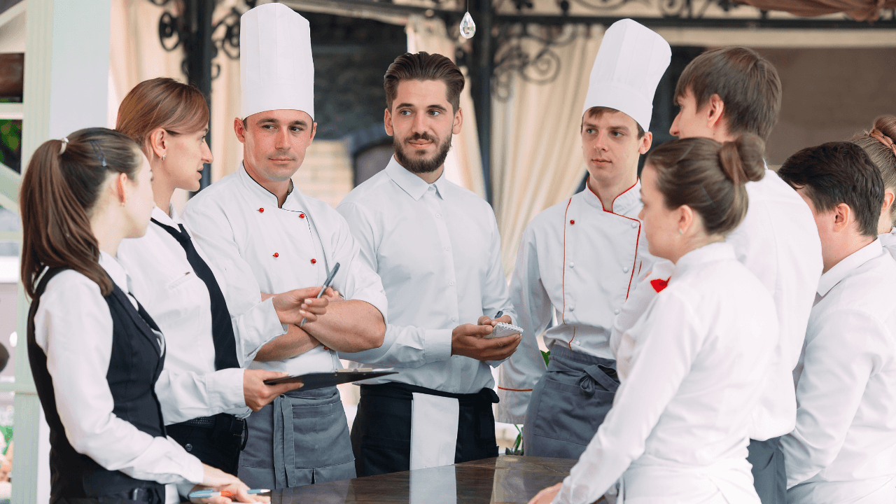 A group of cooks are having a discussion with a manager.