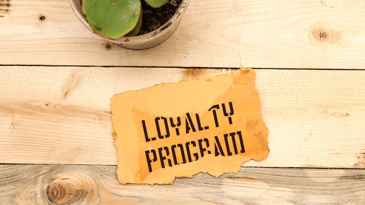 Loyalty program paper placed on the table next to a plant.