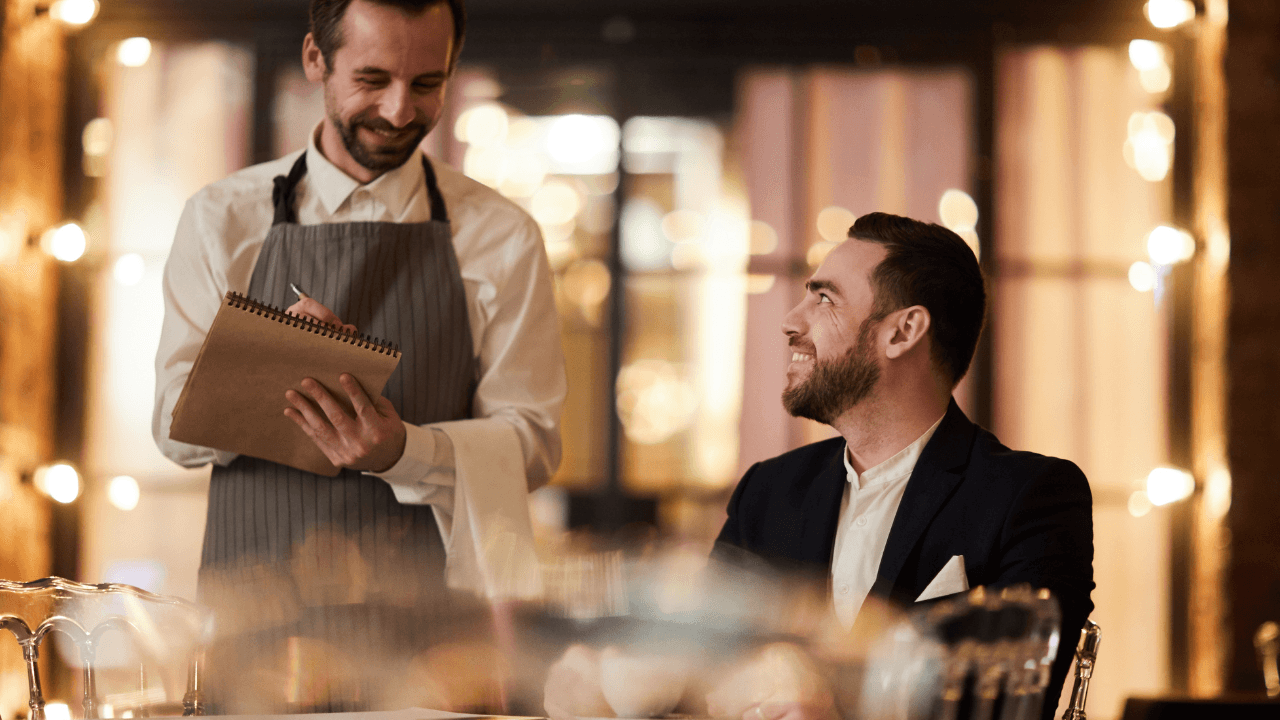 A waiter is taking an order from the customer.
